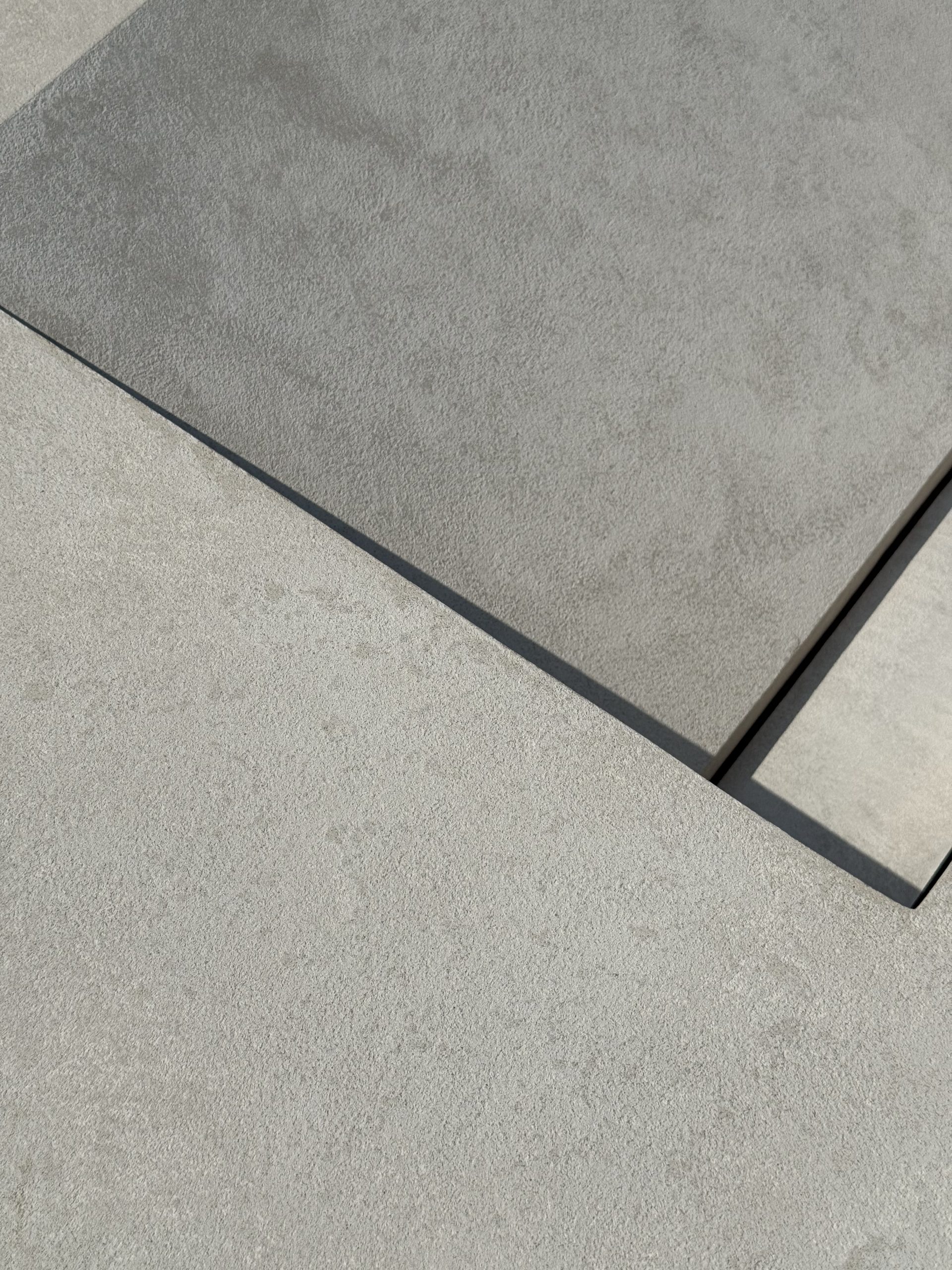 Layered granite-textured microcement panels in daylight