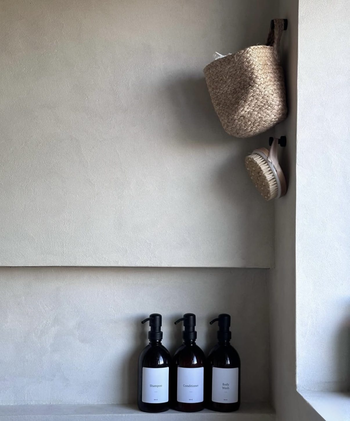 Bathroom shelf in seamless microcement, styled with amenities