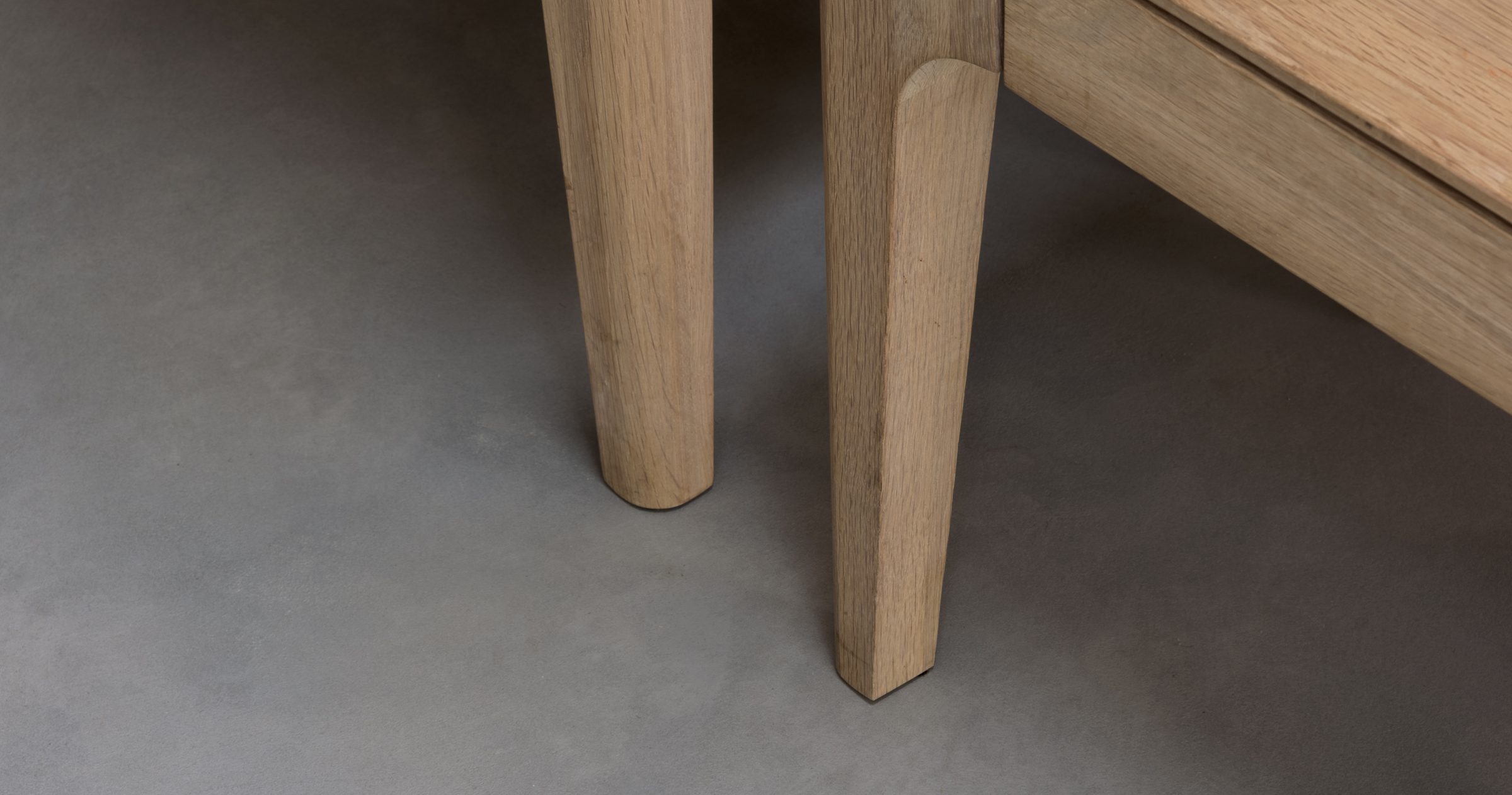 Seamless Micro-Quartz microcement floor running unbroken beneath oak table legs